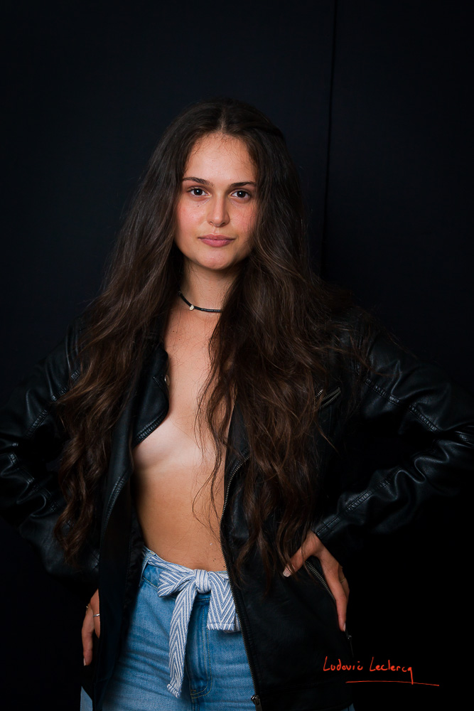 Jeune femme photographiée en studio à Chantilly dans l'Oise. Elle porte un blouson en cuir à même la peau.