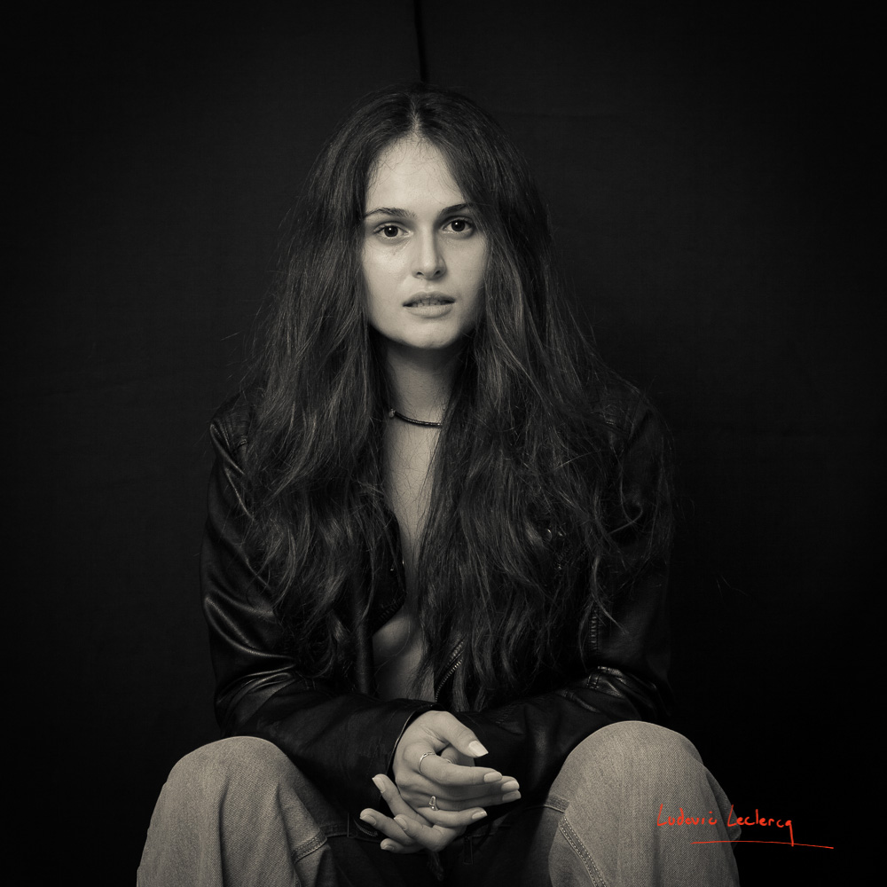 Jeune femme photographiée en noir et blanc en studio.