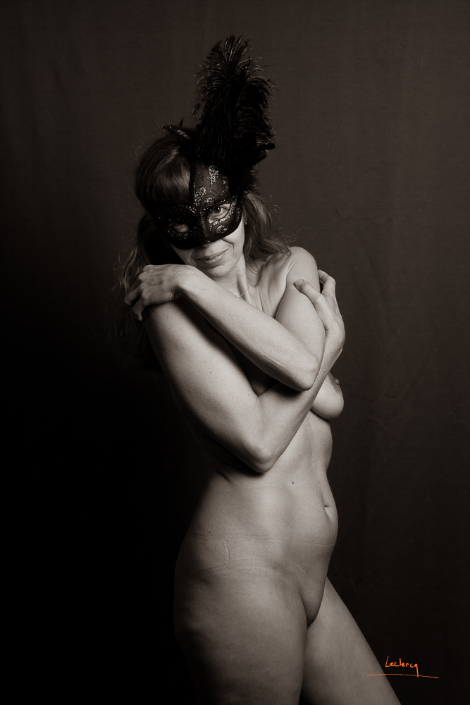 Nu artistique en noir et blanc réalisé en studio. La femme porte un masque.