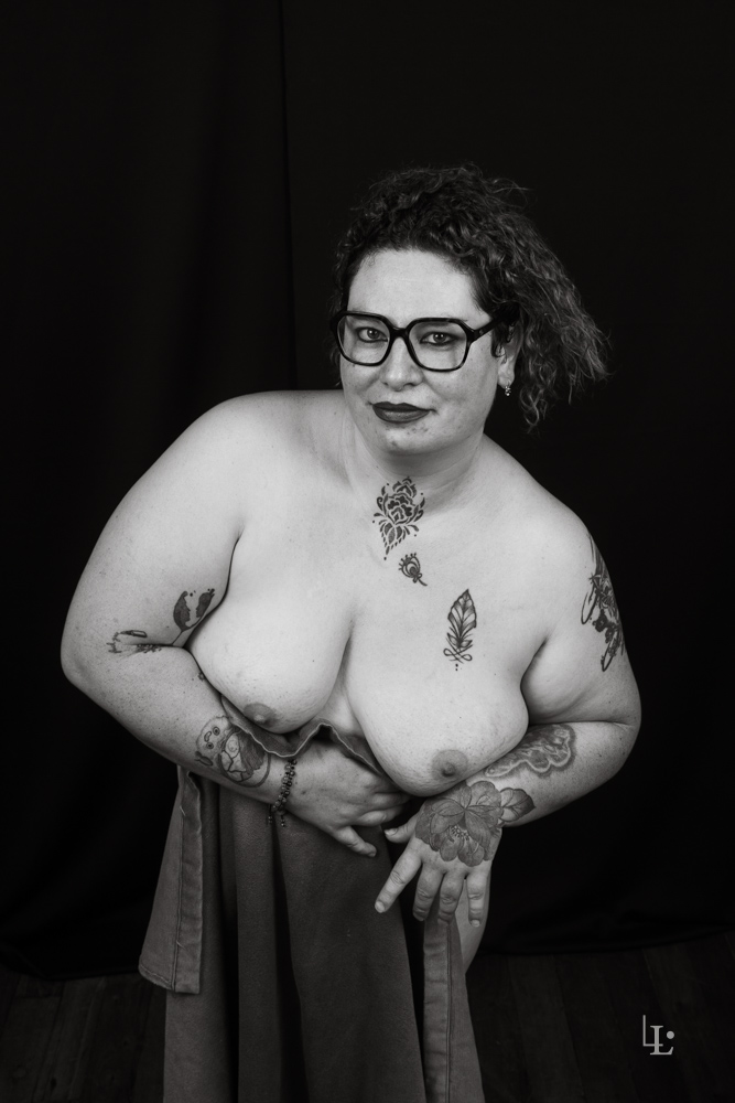 Nu artistique et drapé. Le modèle, une femme porte des lunettes. Photographie studio en noir et blanc.